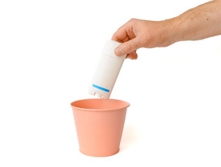 The shampoo bottle is thrown into the trash basket.White isolated background,selective focus