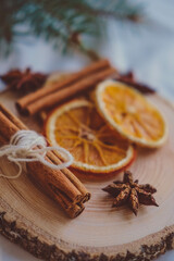 Christmas decoration with dried orange slices, cinnamon sticks and star anise on wooden plate