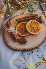 Christmas decoration with dried orange slices, cinnamon sticks and star anise on wooden plate
