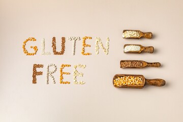 Gluten free text and wooden spoons of various gluten free grains. Flat lay, top
