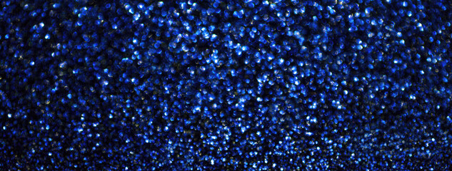 Blurred navy blue sparkling background from small sequins, macro. Blurred defocused sapphire...