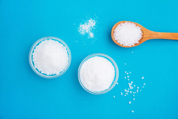 Salt in a wooden spoon, glass bowls and scattered, top vie