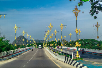 The background of the mountain road has many kinds of large trees, green grass, and the wind blows...