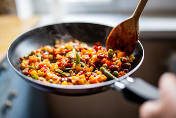 cooking tasty vegetable mix with corn, pea, beans in pan on kitchen - obrazy, fototapety, plakaty