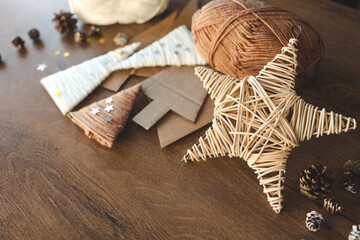 Christmas craft background with handmade yarn cone xmas trees in natural colors. DIY organic sustainable christmas decoration