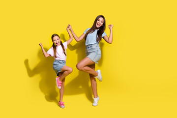 Photo of of two excited sisters raise fists winning school contests isolated over bright color background