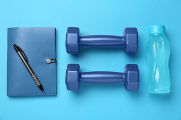 Flat lay composition with dumbbells on light blue background