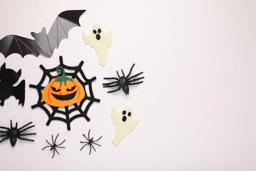 Flat lay composition with Halloween decor on white background, space for text