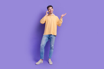 Full body photo of nice young male talk phone look empty space wear trendy yellow outfit isolated on violet color background