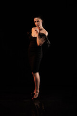 Fototapeta na wymiar brunette woman posing in black studio