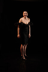 brunette woman posing in black studio