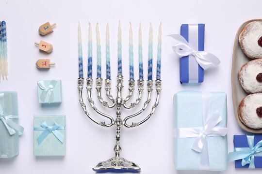 Flat lay composition with Hanukkah menorah and gift boxes on light background