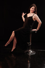 brunette woman posing in black studio