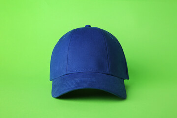 Stylish blue baseball cap on light green background