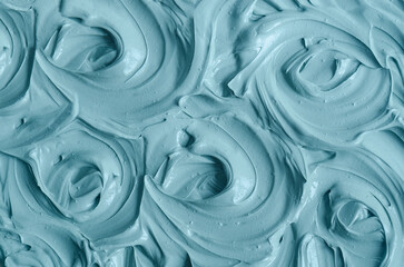 Blue bentonite facial clay (alginate mask, face cream, body wrap) texture close up, selective focus. Abstract background with swirl brush strokes.