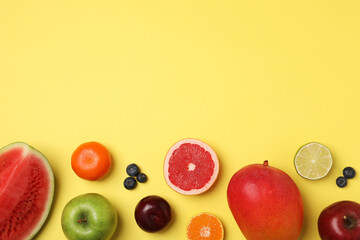 Different ripe fruits on yellow background, flat lay. Space for text