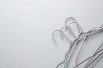 Hangers on light gray background, top view. Space for text