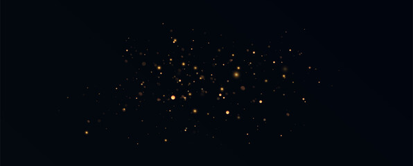 Golden sequins glow with many lights. Glittering dust. Luxurious background of golden particles.	