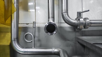 Stainless steel pipe, valve, and storage tank in production room of factory 