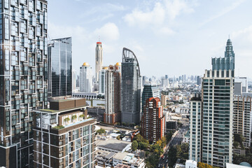 Closeup image of Bangkok cityscape. Modern cityscape surrounded with architectural building with day light and blue sky. Side view. Business background. Day light. Ornamented. - obrazy, fototapety, plakaty