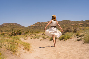 Woman walking free along a sandy path