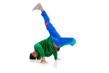 Stylishly dressed man performing freestyle, breakdance, standing on hands raised up legs against...