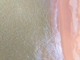 Aerial view of sea crashing waves White foaming waves on beach sand,Top view beach sea surface, Nature sea beach sand background
