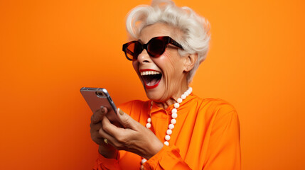 Happy senior woman waving on video call through smart phone against orange background