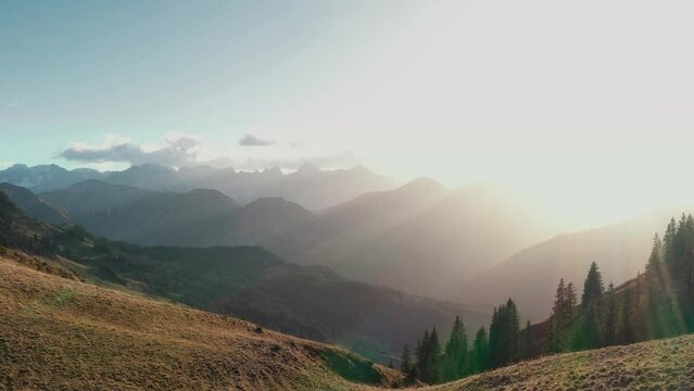 Drone footage of alpine mountain scenery with forests and mountains in the fall with setting sun. Backlit. Achensee, Tirol, Austria