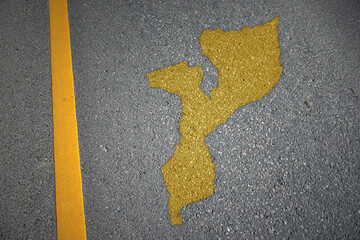 yellow map of mozambique country on asphalt road near yellow line.