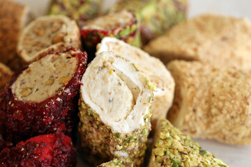 Many rolls of turkish delight with different flavors and fillings close up on table. Cutted Turk Lokumu bars