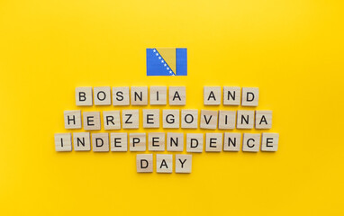 Obraz premium On March 1, Independence Day of Bosnia and Herzegovina, a minimalistic banner with an inscription in wooden letters on an orange background