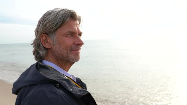 Contemplating the vastness of the ocean, a mature man gazes out to sea