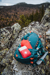 A mountain hike with a backpack, a tourist's equipment on a hike, a first aid kit on the backpack, a box with medicines.