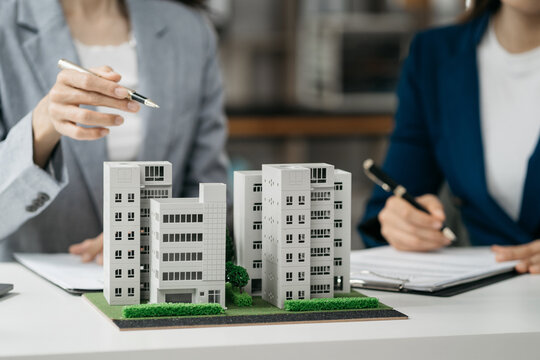 House model with agent asking costumer for contract to buy, get insurance or loan real estate or property.