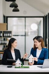 Real estate broker agent presenting and consult to customer to decision making sign insurance form agreement, home model, concerning mortgage loan offer