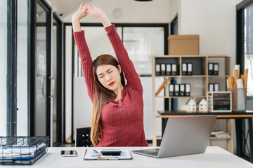 woman is doing a stretchy posture due to sitting in the office for too long, office syndrome...