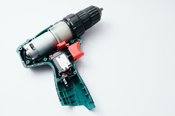 Repair of a Battery screwdriver with a brushless motor. Disassembled screwdriver on a white background.