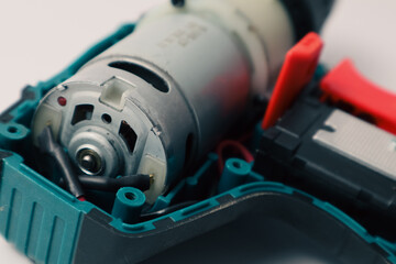 Repair of a Battery screwdriver with a brushless motor. Disassembled screwdriver on a white...
