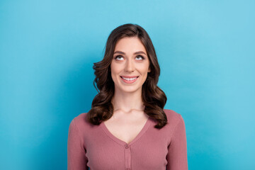 Obraz premium Portrait of toothy beaming girl with curly hairstyle wear elegant clothes look up at offer empty space isolated on blue color background