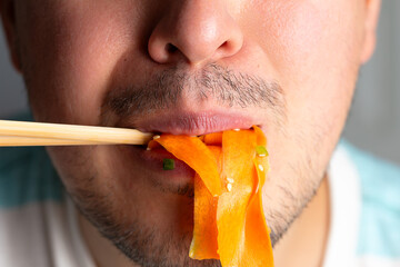 Man eating viral carrot salad wit chopstick