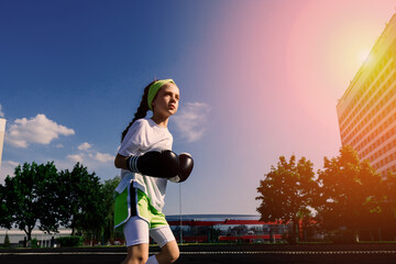 Female child boxer in gloves, feminism concept. Back to school, physical training lesson.