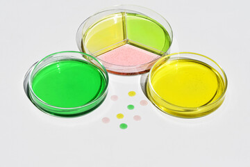 Petri dishes with colored liquid and drops around. Scientific concept