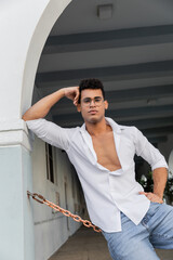 Fototapeta na wymiar Young sexy and stylish cuban man in white shirt and eyeglasses on urban street in Miami