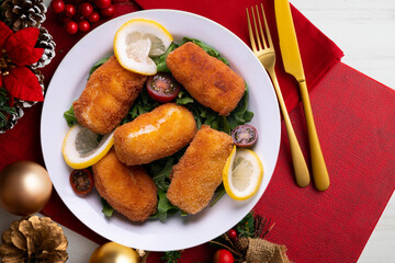 Fish croquettes. Traditional tapas of the coastal areas in Spain. Christmas food served on a table decorated with Christmas motifs.