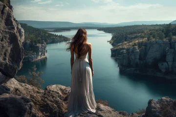 Foto op Canvas Woman on a cliff with a huge lake in the background © Tymofii