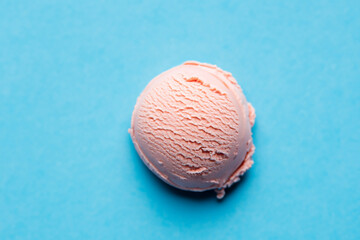 Scoop of strawberry ice cream on a blue background. Selective focus.
