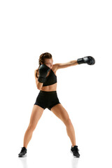 Striking image of female professional boxer in action, wearing gloves and shorts, standing out against plain white studio background.