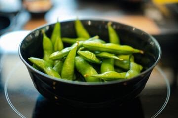 Green Japanese soybean in black bowl. Close up