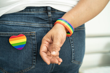 Woman holding LGBT rainbow colorful flag, symbol of lesbian, gay, bisexual, transgender, human rights, tolerance and peace.
